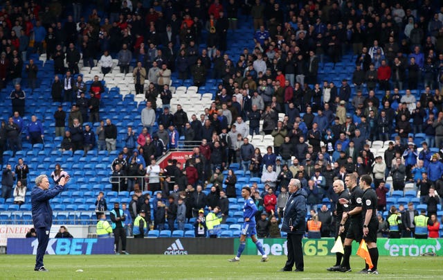 Neil Warnock, left, applauds the Cardiff fans while waiting for referee Craig Pawson, second right, and the other match officials