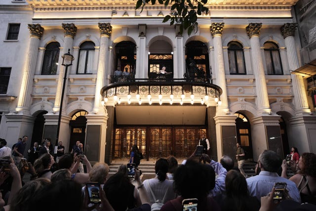 Crowds watch Rachel Zegler on a balcony at the London Palladium