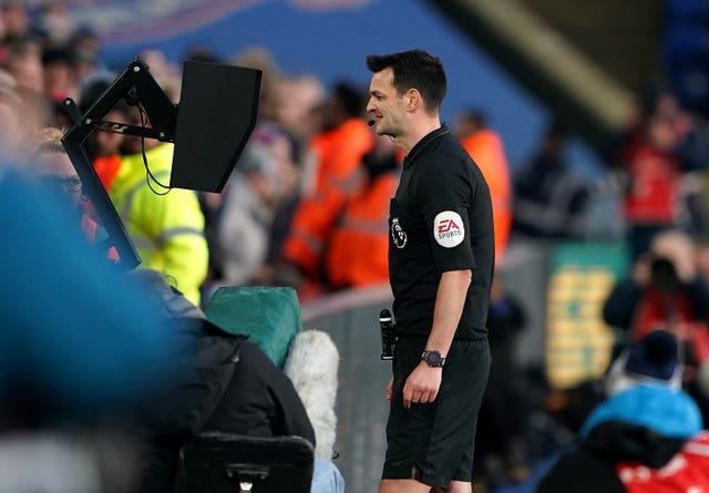 Referee Andrew Madley checks the VAR screen before rescinding a red card shown to Crystal Palace's Joel Ward against Sheffield United