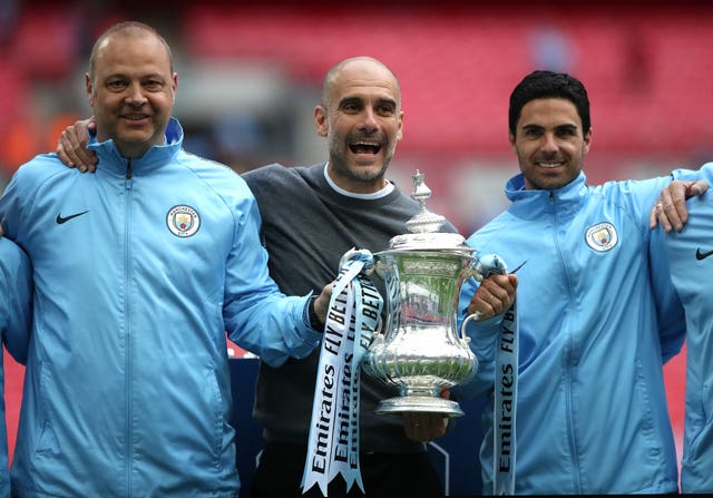 Mikel Arteta, right, celebrates alongside Pep Guardiola, centre, with the FA Cup