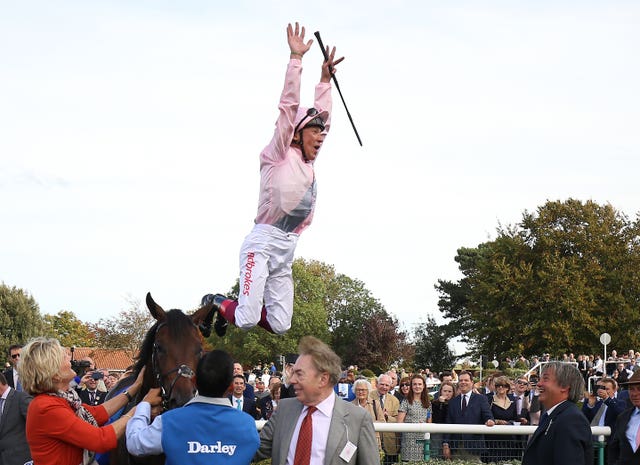 Frankie Dettori leaps from Too Darn Hot after winning the Dewhurst Stakes