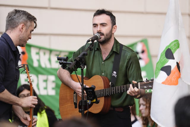 A guitarist performs among supporters of Kneecap’s Liam Og O Hannaidh outside Westminster Magistrates’ Court in London
