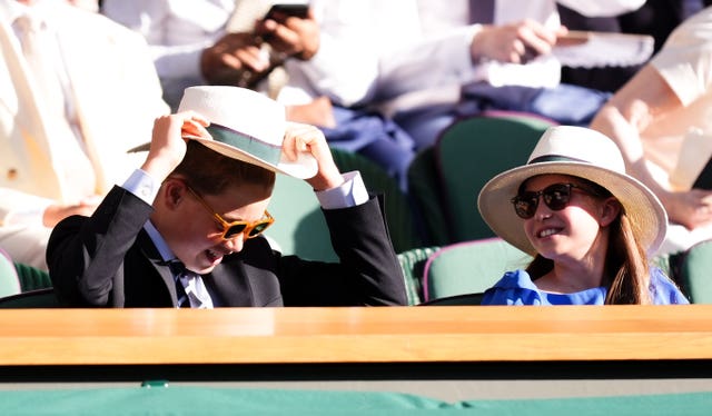 Prince George and Princess Charlotte wearing hats and sunglasses in the royal box at Wimbledon