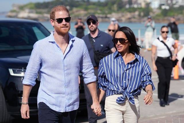 The Duke and Duchess of Sussex walk hand in hand during a visit to Australia