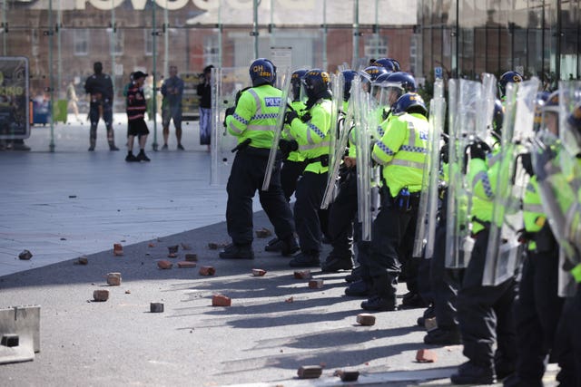 Rubble lies at the feet of police officers in Liverpool during the disorder in the city on August 3 2024