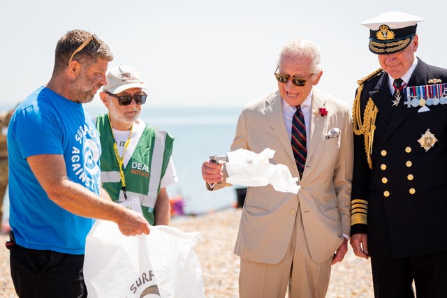 Really happy King picks up litter on a beach
