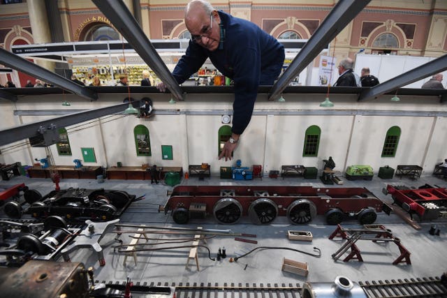 A model engineer looks at pieces from a model train depot