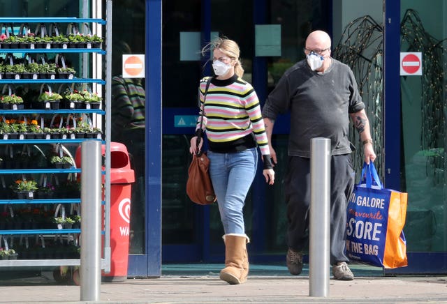 People carry their shopping after visiting a home, garden and leisure store in Kent