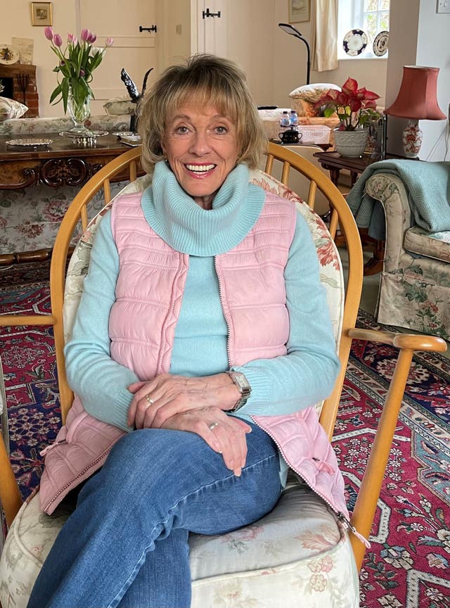 Dame Esther Rantzen sitting in a chair at home