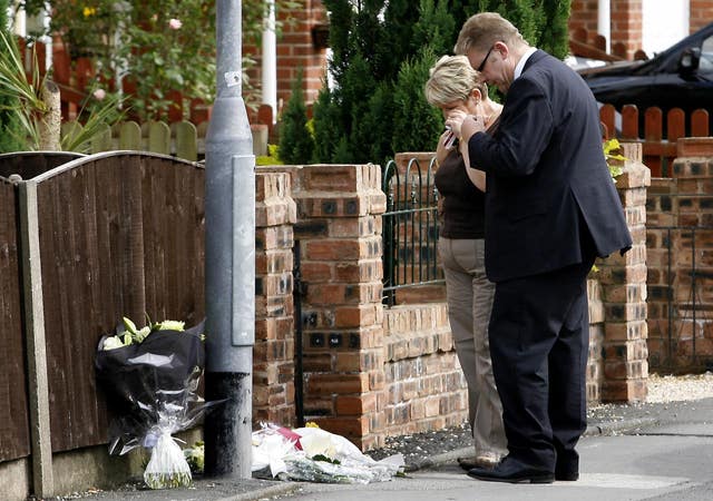 Passers-by look at flowers left on Station Road North