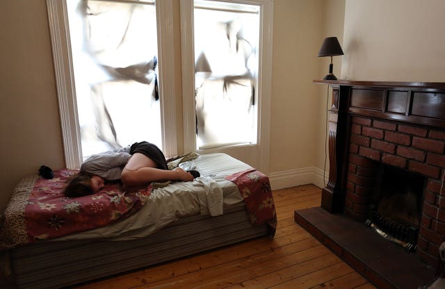 A woman looking scared on a bed