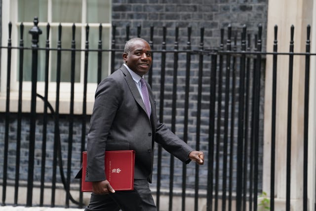 David Lammy walking on Downing Street carrying a red Government folder under his arm