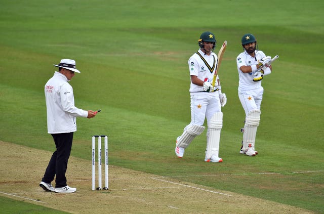 Pakistan's Mohammad Rizwan and Naseem Shah leave the pitch for bad light as the umpire takes a light reading 