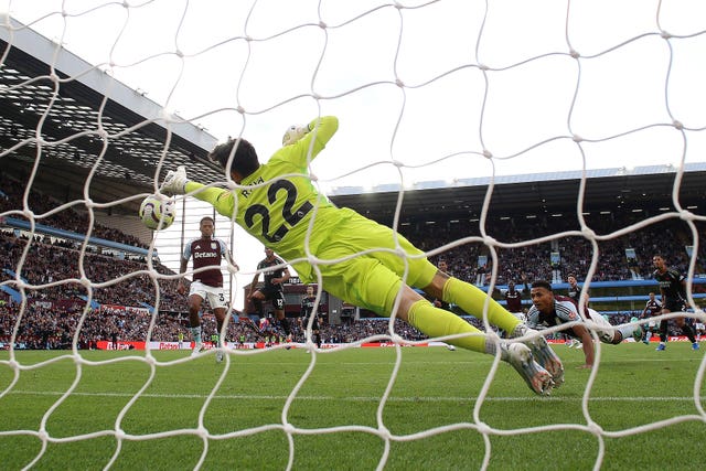 Arsenal goalkeeper David Raya dives to his left to save a header from Aston Villa''s Ollie Watkins, right