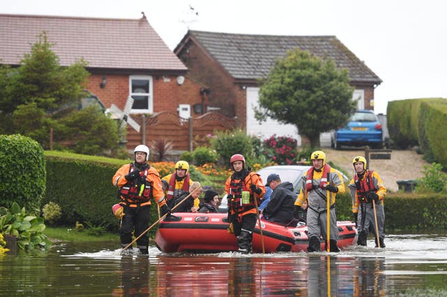 Residents are taken to safety in an inflatable boat by rescue workers in Wainfleet (Joe Giddens/PA)