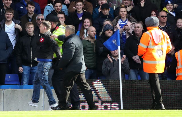 The fan who attacked Aston Villa's Jack Grealish is escorted off the pitch during Birmingham's 1-0 defeat at St Andrew's 
