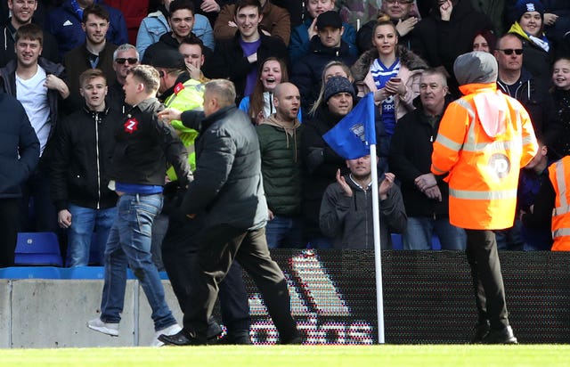 The fan who attacked Aston Villa's Jack Grealish is escorted off the pitch during Birmingham's 1-0 defeat at St Andrew's