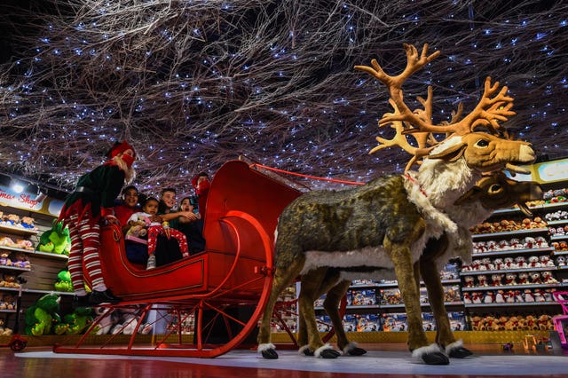 Staff and children sit in a sleigh during the Hamleys Christmas toy showcase at Hamleys, Regent Street, London