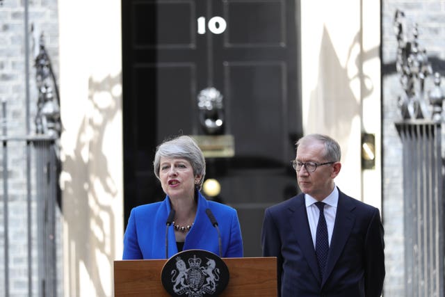 Theresa May issues a statement outside 10 Downing Street, watched by her husband Philip