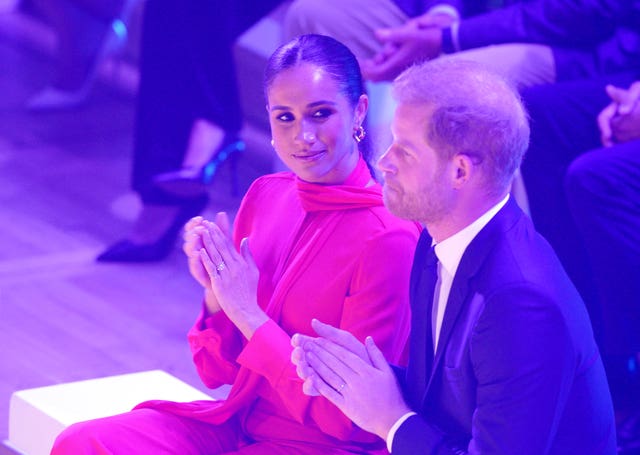 Meghan looks at Harry as they sit and applaud during a One Young World Summit in Manchester