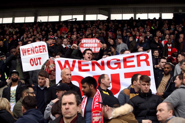 Fans hold up a Wenger Out banner