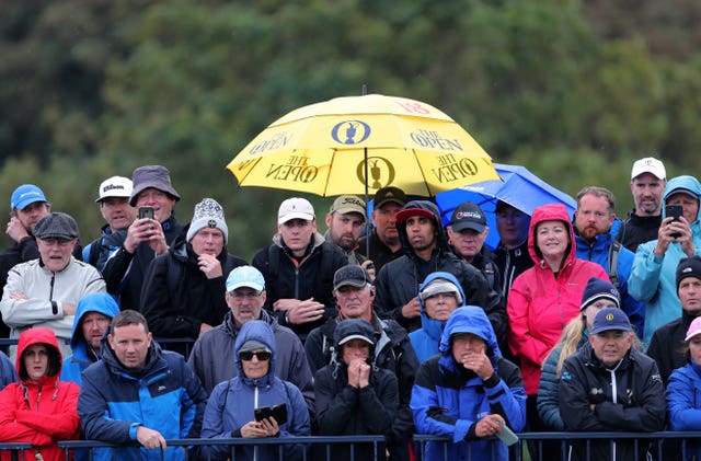 Fans shelter from the rain