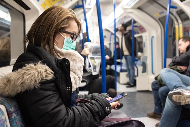 A woman wearing a facemask on the London Underground