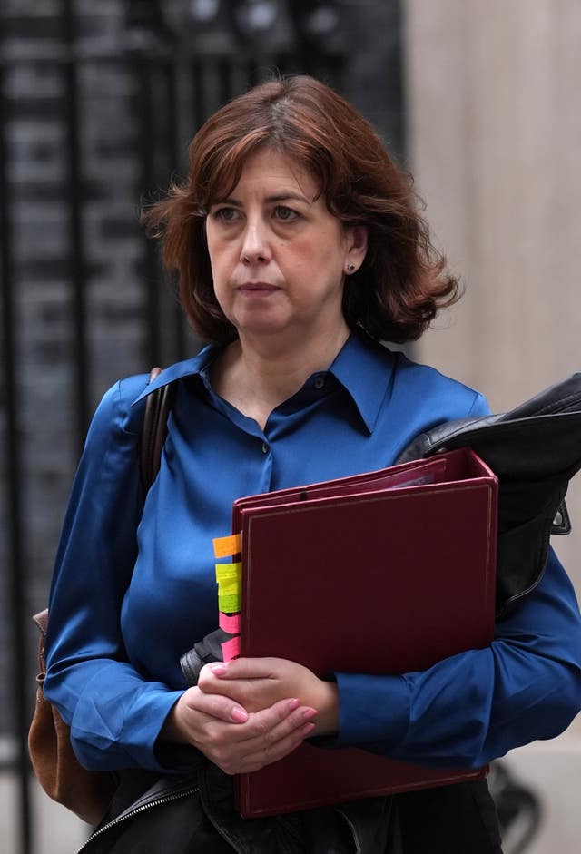 Education Secretary Lucy Powell walking outside, carrying a folder
