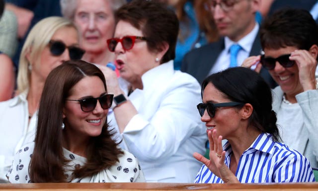 The Duchess of Cambridge and The Duchess of Sussex in the royal box on centre court on day twelve of the Wimbledon Championships at the All England Lawn Tennis and Croquet Club, Wimbledon.