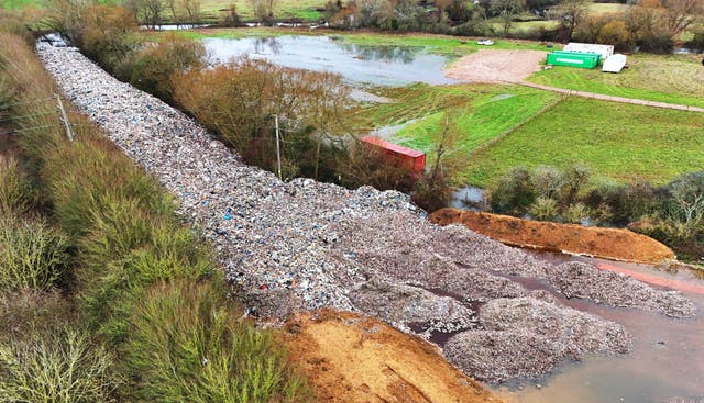 An aerial shot of the 150m long mountain of rubbish between two lines of trees before work to clear it began