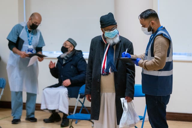 People attend a temporary coronavirus vaccination centre at the East London Mosque, in Whitechapel 