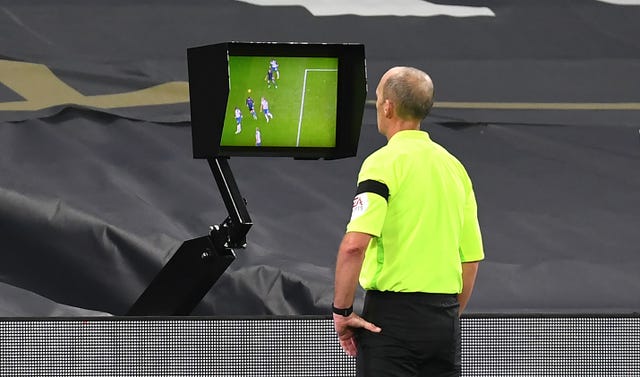 Referee Mike Dean consults the VAR screen before disallowing a goal for Manchester City's Aymeric Laporte 