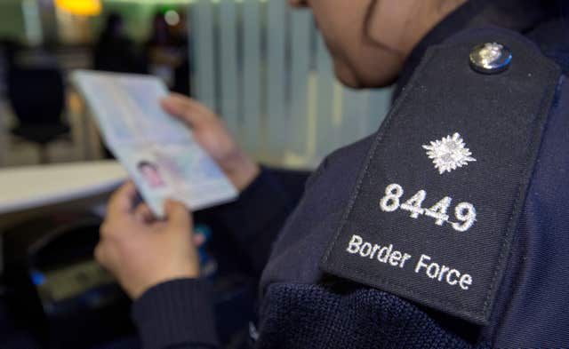 An officer checking passports (Steve Parsons/PA)