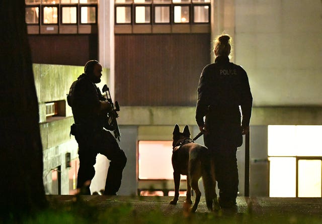 An armed police officer and a police dog and handler outside the London Central Mosque, near Regent’s Park, London (Dominic Lipinski/PA)