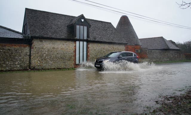 A car passing through a flooded road in Ashford, Kent