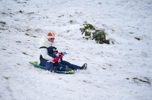 People sledging in the snow