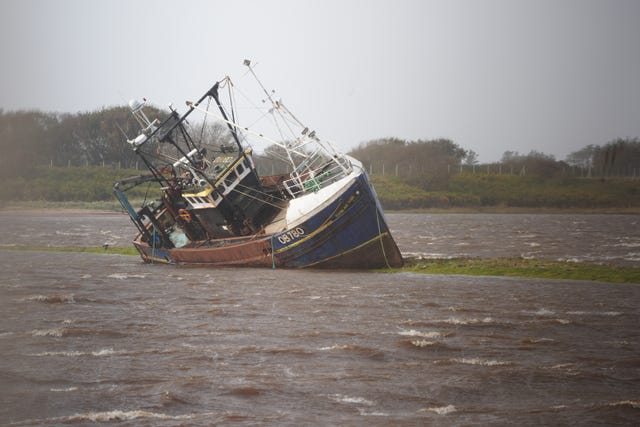 A fishing boat is stranded at Irvine Harbour in North Ayrshire after coming loose from its moorings during Storm Boelo