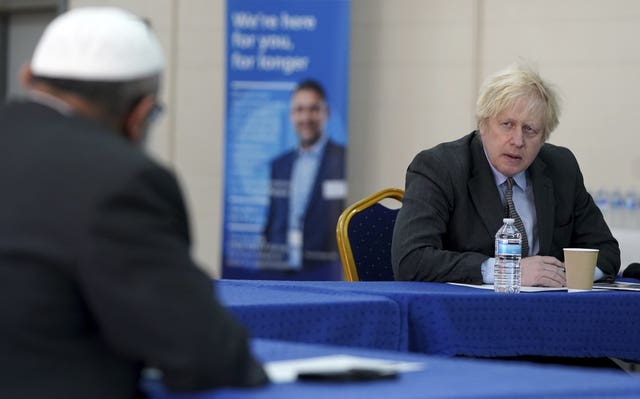 Prime Minister Boris Johnson speaks to members of staff during a visit to a coronavirus vaccination centre in Batley, West Yorkshire (Jon Super/PA)
