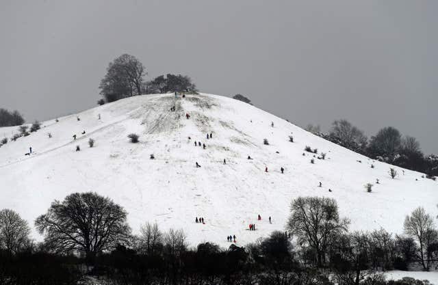 People enjoy a snow covered hill near Princes Risborough, Buckinghamshire, following a weekend wintry blast in December (Steve Parsons/PA)