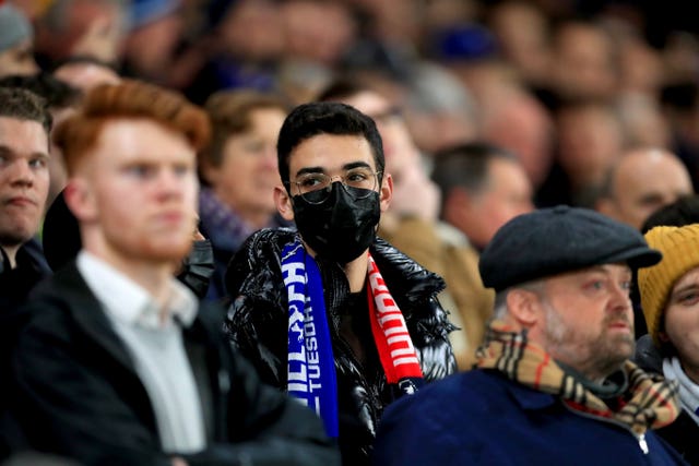 A football fan wearing a face mask in the crowd of a match