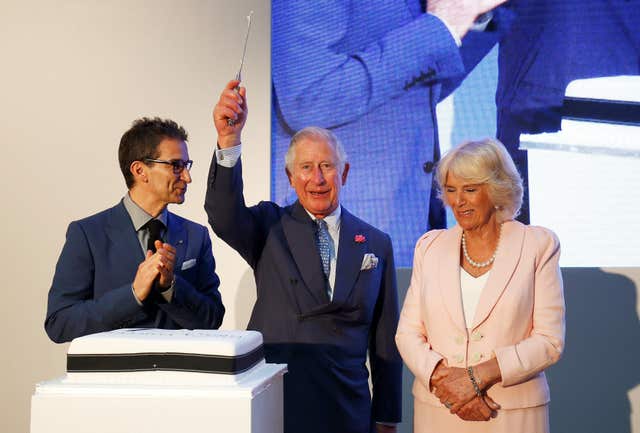 Charles and Camilla prepare to cut a cake (Henry Nicholls/PA)