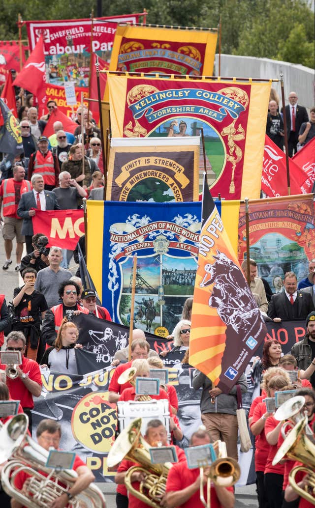 Demonstrators march with banners