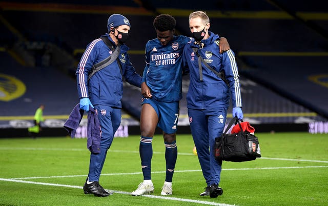 Bukayo Saka, centre, seemed to hurt his knee in the goalless draw at Arsenal (Michael Regan/PA)