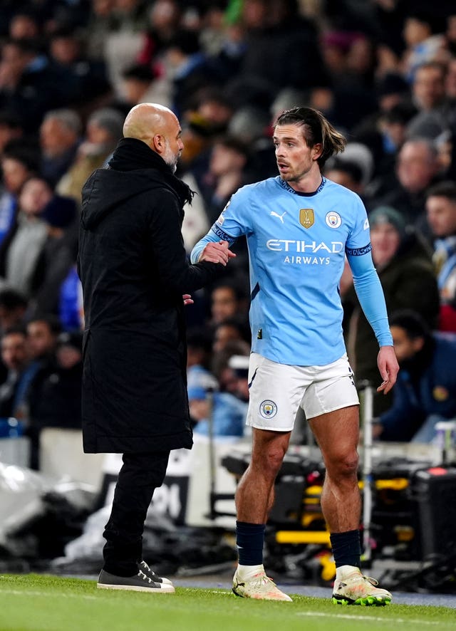 Manchester City manager Pep Guardiola talks with Jack Grealish on the touchline