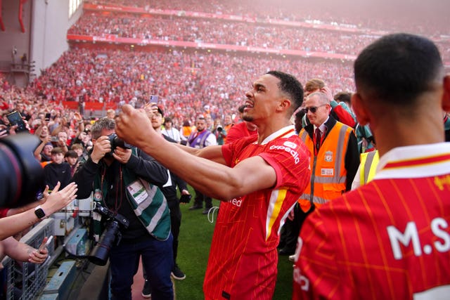 Trent Alexander-Arnold, centre, and Mohamed Salah, right, celebrate Liverpool’s Premier League title with fans at Anfield