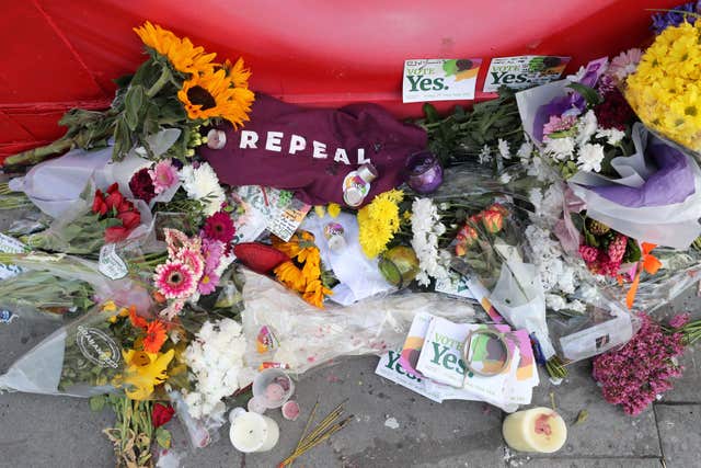 Floral tributes underneath a mural of Savita Halappanavar in Dublin (Niall Carson/PA)