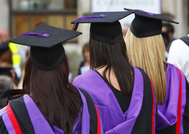 Three graduates wearing gowns and caps