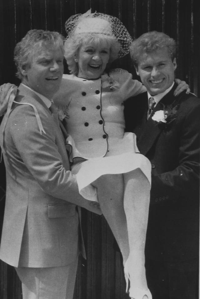 Coronation Street bride Ivy Tilsley, played by actress Lynne Perrie, is given a lift by her groom, Don Brennan, played by Geoff Hinsliff, and screen son Brian, played by Chris Quinten, after her screen wedding