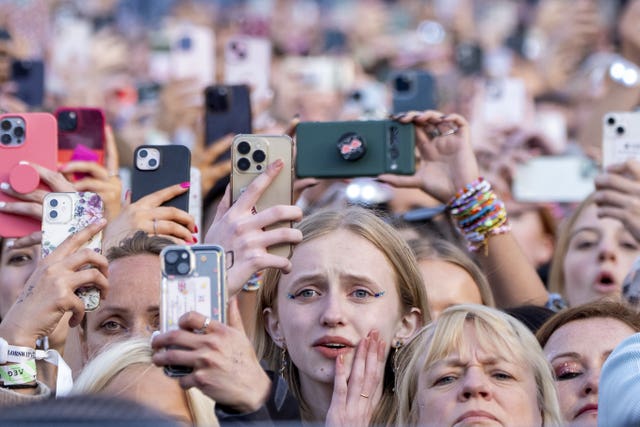 Taylor Swift fans holding up their phones to record the star