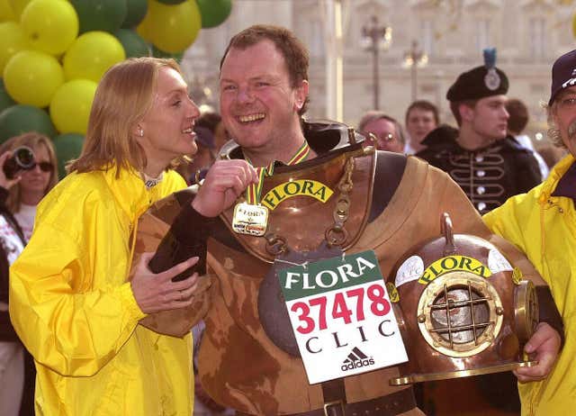 Women's elite race winner Paula Radcliffe greets charity runner Lloyd Scott, who 'ran' the race wearing an antique diving suit in the slowest ever marathon time of five days, eight hours, 29 minutes and 46 seconds. Lloyd was raising money in aid of Cancer & Leukaemia in Childhood 